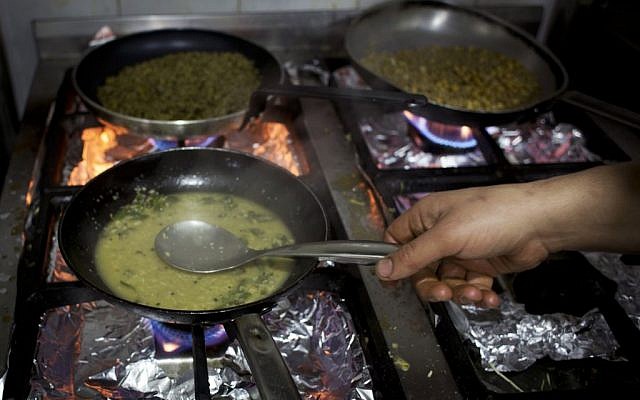In this photo taken on Saturday February 20, 2016, Palestinian chef Jihad al-Maharmeh prepares a mixed Palestinian French dish, Freekeh lamb rack at Orjuwan restaurant in the West Bank city of Ramallah. (AP/Nasser Nasser) 