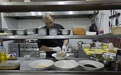 In this photo taken on Saturday Feb. 20, 2016, Palestinian chef Jihad al-Maharmeh prepares a mixed Palestinian French dish, Freekeh lamb rack at Orjuwan restaurant in the West Bank city of Ramallah. At a time of simmering Mideast tensions and rising malaise, a group of French chefs recently visited the West Bank to bring a little joie de vivre to Palestinian kitchens. (AP Photo/Nasser Nasser)