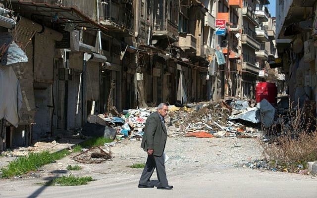 A Syrian man walks through a devastated part of the old city of Homs, Syria, February 26, 2016. (AP/Hassan Ammar) A Syrian man walks through a devastated part of the old city of Homs, Syria, February 26, 2016. (AP/Hassan Ammar)