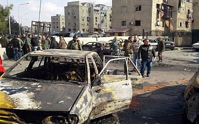 Soldiers and plainclothes policemen gather at the scene of an explosion that killed tens of people and wounded others in the Syrian capital of Damascus on Tuesday Feb. 9, 2016 (SANA via AP)