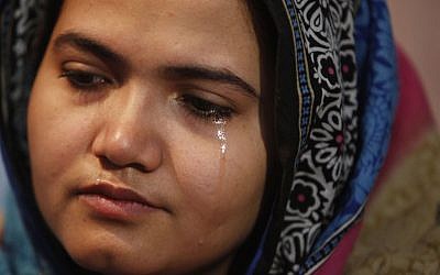 In this photo taken on Jan. 26, 2016, Kainaat Soomro weeps during an interview with The Associated Press in Karachi, Pakistan. She was 13 years old and on her way to buy a toy for her newborn niece when three men kidnapped her, held her for several days and repeatedly raped her. Eight years later, she is still battling for justice. (AP Photo/Shakil Adil)