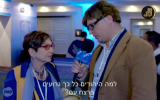 A fake foreign journalist asks an Israeli woman, 'Why are the Jews so bad at genocide?' during a segment for the comedic television show, 'Hayom ba'Lila with Guri Alfi,' which pokes fun at the perceived hatred of the foreign media towards Israel on February 21, 2016. (Screen capture)