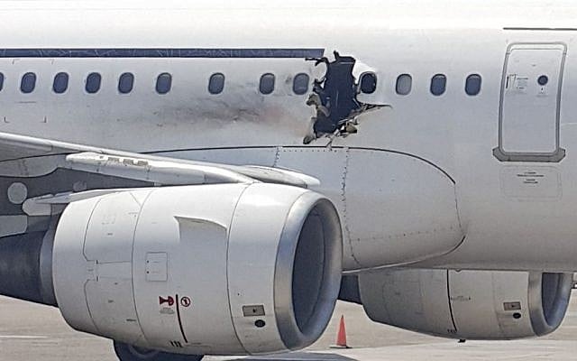 In this Tuesday, Feb. 2, 2016 photo, a hole is photographed in a plane operated by Daallo Airlines as it sits on the runway of the airport in Mogadishu, Somalia. (AP Photo) In this Tuesday, Feb. 2, 2016 photo, a hole is photographed in a plane operated by Daallo Airlines as it sits on the runway of the airport in Mogadishu, Somalia. (AP Photo)