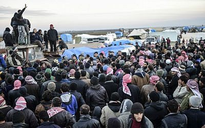 Syrians fleeing the embattled northern city of Aleppo wait near a crossing into Turkey in Bab-Al Salama, near the northern city of Azaz, on February 5, 2016. (AFP/Bulent Kilic)