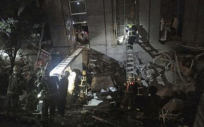 Rescuers are seen entering an office building that collapsed on its side from an early morning earthquake in Tainan, southern Taiwan, Saturday, Feb. 6, 2016. A 6.4-magnitude earthquake has struck southern Taiwan, according to the U.S. Geological Survey. (AP Photo)