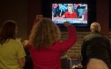 Staff and volunteers of the Hillary Clinton Burlington, Iowa campaign field office cheer as Hillary Clinton speaks on the television at the Boogaloo Cafe on February 1, 2016 in Burlington, Iowa. (AFP / Michael B. Thomas)