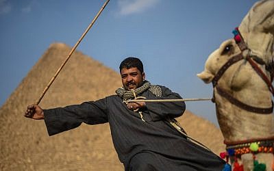 An Egyptian man rides a camel in front of one the Giza pyramids in the southern Cairo Giza district on January 20, 2016. Since President Abdel Fattah al-Sisi ousted Islamist leader Mohamed Morsi in 2013, a deadly insurgency led by the Islamic State jihadist group has kept away millions of tourists. (CreditMOHAMED EL-SHAHED / AFP) 