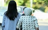 An illustrative photo of a Filipina worker helping an elderly woman on November 2, 2010. (Moshe Shai/Flash90)