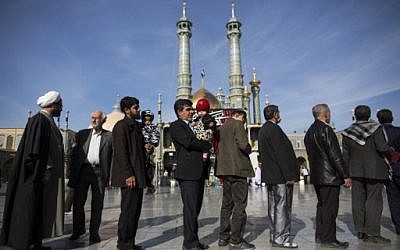 Iranians hold their identification cards as they line up outside a polling station at Massoumeh shrine during the parliamentary and Assembly of Experts elections at a polling station in the holy city of Qom, 130kms south of the capital Tehran, on February 26, 2016. (AFP / BEHROUZ MEHRI)