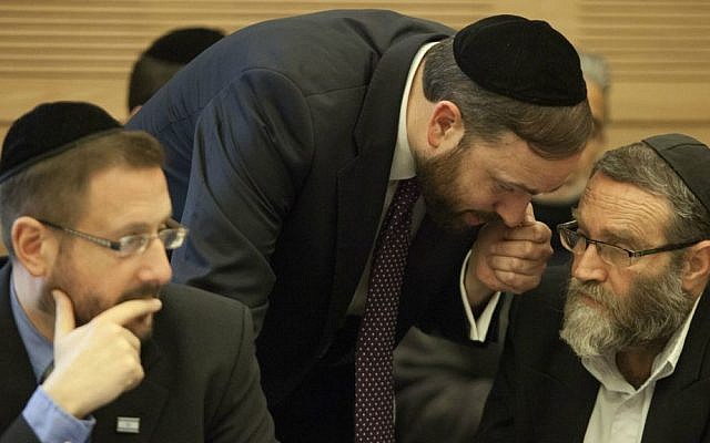MKs Moshe Gafni, right, and Ariel Atias, center, discuss their strategy in opposing a bill requiring Haredim to join the army, not realizing that Lipman, a staunch advocate of the bill, can hear every word. February 17, 2014. (Flash90)