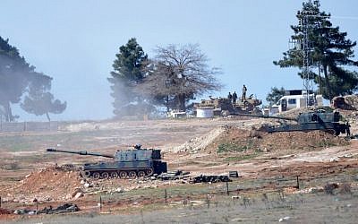 Tanks stationed at a Turkish army position near the Oncupinar crossing gate close to the town of Kilis, south central Turkey, fire towards the Syria border, on February 16, 2016. (AFP/BULENT KILIC)
