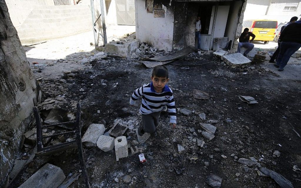 A Palestinian boy walks above debris at the Qalandya Refugee camp in the West Bank following clashes between Palestinian youths and Israeli security forces on March 1, 2016 (AFP / ABBAS MOMANI)