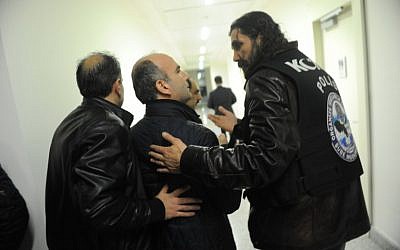 Turkish police officers escort Abdulhamit Bilici (C), editor in chief of Zaman, out of the newspaper's Istanbul headquarters on March 5, 2016. (AFP/SELAHATTIN SEVI)