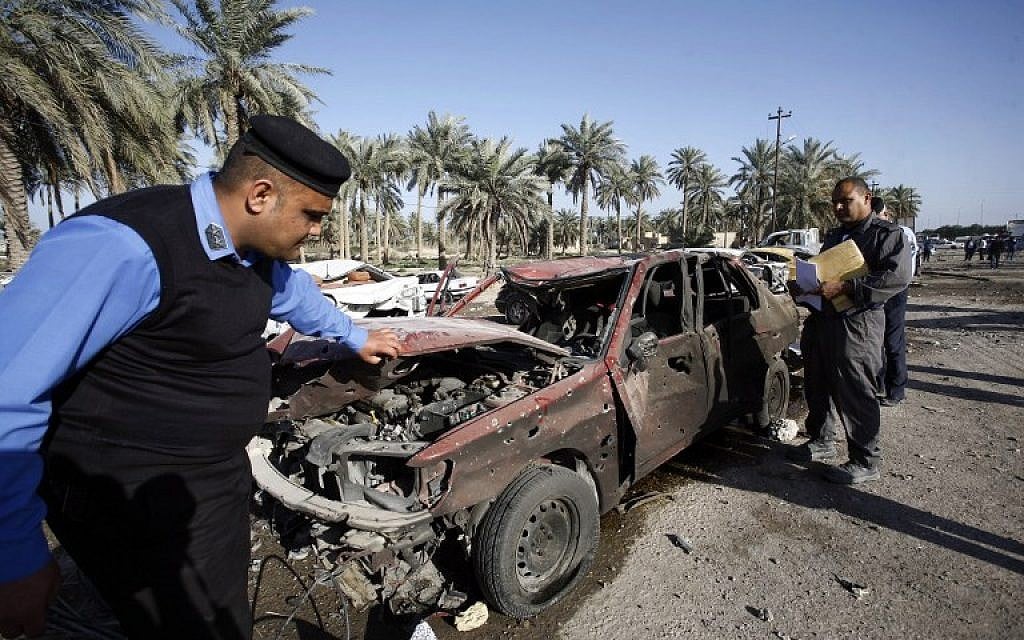 Iraqi emergency responders inspect debris at the site of a truck bomb that exploded at a crowded checkpoint in the Iraqi city of Hilla, south of Baghdad, on Sunday, March 6, 2016 (AFP / HAIDAR HAMDANI)