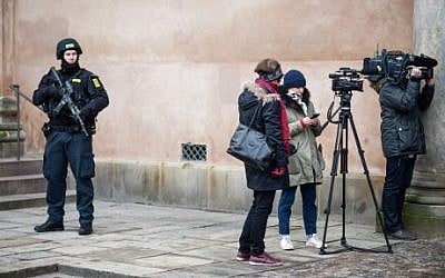 A Danish policeman looks at journalists as he stands guard in front of the city court in Copenhagen, Denmark, where a trial is to open on March 10, 2016 against four men accused of helping a Danish-born gunman whose attacks on a synagogue and a free speech event last year left two people dead. / AFP / SCANPIX DENMARK / Emil Hougaard / Denmark OUT