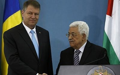 Palestinian Authority President Mahmoud Abbas (R) and Romanian President Klaus Iohannis shake hands during a joint press conference in the West Bank city of Ramallah on March 10, 2016. (AFP/ABBAS MOMANI)
