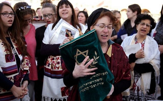 A member of the Women of the Wall wears a tallit (prayer shawl) as she prays holding a Torah scroll at the Western Wall in Jerusalem on March 11, 2016 (AFP/GALI TIBBON)