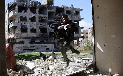 A fighter belonging to Jaish al-Islam (Islam Army) runs to take cover near the frontline on March 14, 2016 in the neighbourhood of Jobar, on the eastern outskirts of the capital Damascus. (AFP / AMER ALMOHIBANY)