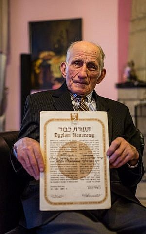 Picture taken on March 16, 2016 in Nowy Sacz, Poland, shows Jozef Jarosz presenting a diploma of Yad Vashem "Righteous Among the Nations" for his family for helping Anna Grygiel and other 13 Jews to survive the Holocaust and WWII. (AFP / WOJTEK RADWANSKI)