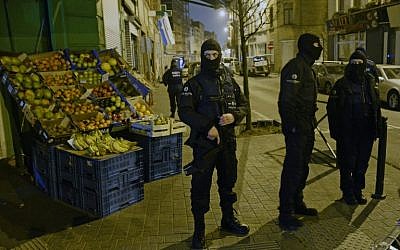 Police stand guard near a scene of a police operation in the Molenbeek-Saint-Jean district in Brussels, on March 18, 2016, as part of the investigation into the Paris November attacks. (AFP/BELGA/Dirk Waem)