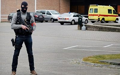 The ambulance believed to be transporting top Paris attacks suspect Salah Abdeslam arrives at the Bruges prison, on March 19, 2016 as a police officer stands guard at the entrance of the prison. AFP / Belga / STEPHANIE DEMASURE )
