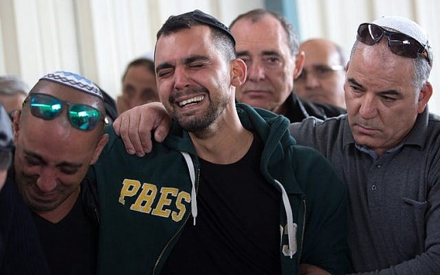 The children (L and C) of 60-year-old Simcha Damri mourn during her funeral in the southern Israeli city of Dimona on March 21, 2016. (AFP / MENAHEM KAHANA