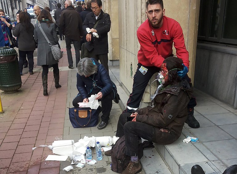 A private security guard helps a wounded women outside the Maalbeek metro station in Brussels on March 22, 2016 after a blast at this station located near the EU institutions. (AFP / Michael VILLA) A private security guard helps a wounded woman outside the Maalbeek metro station in Brussels on March 22, 2016 after a blast at this station located near the EU institutions. (AFP / Michael VILLA)