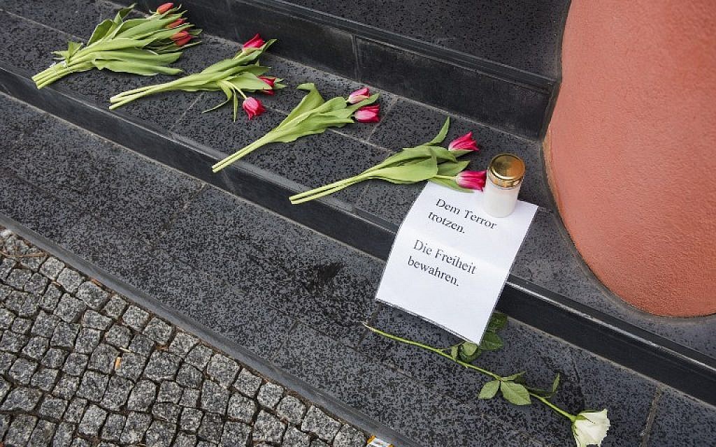 A man looks at flowers and a sign reading "Defy terror, protect freedom" outside the Belgium Embassy in Berlin on March 22, 2016 (AFP / ODD ANDERSEN)