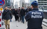 A Belgian police officer stands guard as people are evacuated from the Wetstraat - Rue de la Loi after an explosion at the Maalbeek subway station in Brussels on March 22, 2016. (Philippe Francois/AFP)
