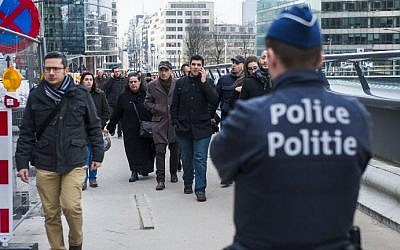 A Belgian police officer stands guard as people are evacuated from the Wetstraat - Rue de la Loi after an explosion at the Maalbeek subway station in Brussels on March 22, 2016. (Philippe Francois/AFP)