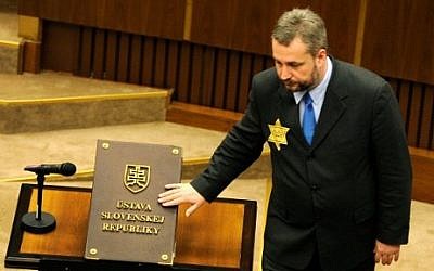 Ondrej Dostal, member of OLaNO-NOVA party with a yellow David star on his jacket, takes the oath of office on the Slovak Constitution, March 23, 2016.  (AFP/SAMUEL KUBANI)