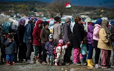 People line up for food distributed at a makeshift camp occupied by migrants and refugees at the Greek-Macedonian border near the village of Idomeni on March 24, 2016. (AFP / ANDREJ ISAKOVIC)