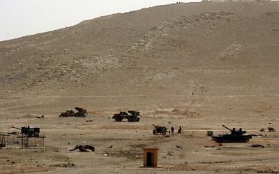 Syrian troops are seen deployed in a field in the ancient city of Palmyra on March 24, 2016. (AFP / STR) Syrian troops are seen deployed in a field in the ancient city of Palmyra on March 24, 2016. (AFP / STR)