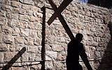 A Catholic pilgrim carries a wooden cross along the Via Dolorosa (Way of Suffering) in Jerusalems Old City during the Good Friday procession on March 25, 2016. (Gali Tibbon/AFP)