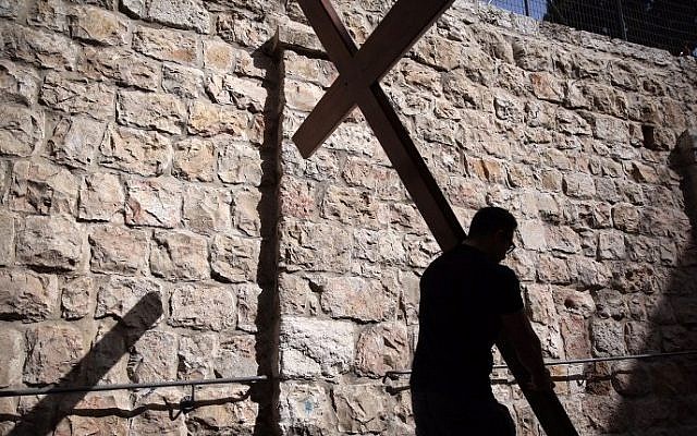 A Catholic pilgrim carries a wooden cross along the Via Dolorosa (Way of Suffering) in Jerusalems Old City during the Good Friday procession on March 25, 2016. (Gali Tibbon/AFP) A Catholic pilgrim carries a wooden cross along the Via Dolorosa (Way of Suffering) in Jerusalems Old City during the Good Friday procession on March 25, 2016. (Gali Tibbon/AFP)