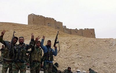 Syrian pro-government forces gesture next to the Palmyra citadel on March 26, 2016, during a military operation to retake the ancient city from the Islamic State group (AFP / Maher AL MOUNES)