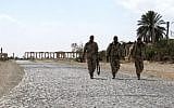 Syrian troops walk in the ancient city of Palmyra after they recaptured the site from the Islamic State group on March 27, 2016. (AFP/Stringer)