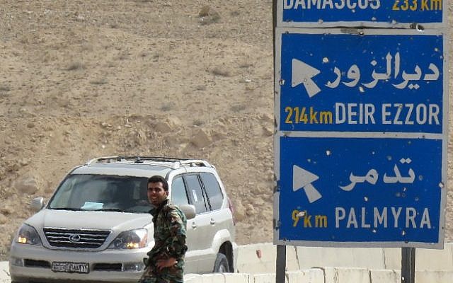 A member of the Syrian government forces sits by a sign post on the outskirts of the ancient city of Palmyra, after they recaptured the UNESCO world heritage site from the Islamic State group on March 27, 2016. (AFP/STRINGER) A member of the Syrian government forces sits by a sign post on the outskirts of the ancient city of Palmyra, after they recaptured the UNESCO world heritage site from the Islamic State group on March 27, 2016. (AFP/STRINGER)