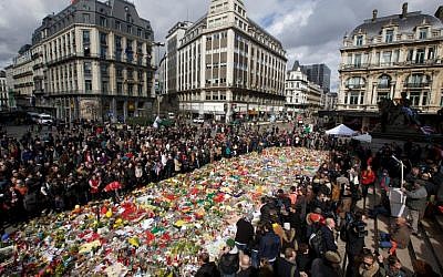 People gather to pay a tribute  on March 27, 2016 outside the stock exchange in Brussels, which has become an unofficial shrine to victims of the March 22 terror attacks in the city. (AFP/Belga/Nicolas Maeterlinck)