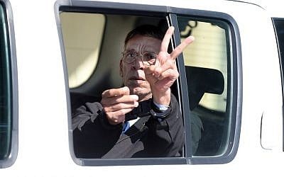 Seif al-Din Mohamed Mostafa, who hijacked an EgyptAir passenger plane the previous day and forced it to divert to Cyprus, flashes the "V" for victory sign as he leaves the court in Larnaca in a police car, March 30, 2016. (AFP/George Michael)