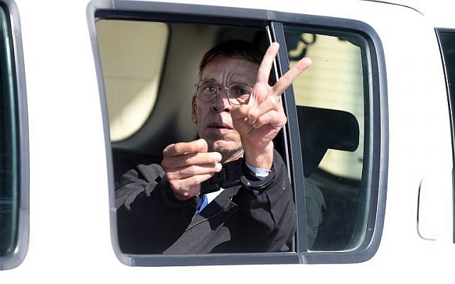 Seif al-Din Mohamed Mostafa, who hijacked an EgyptAir passenger plane the previous day and forced it to divert to Cyprus, flashes the "V" for victory sign as he leaves the court in Larnaca in a police car, March 30, 2016. (AFP/George Michael)
