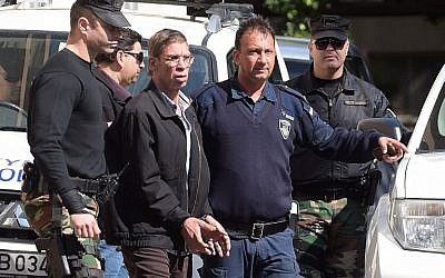 Seif al-Din Mohamed Mostafa, center, an Egyptian man who hijacked an EgyptAir passenger plane the previous day and forced it to divert to Cyprus,  wears handcuffs as he leaves the court in Larnaca escorted by Cypriot police, March 30, 2016. (AFP/GEORGE MICHAEL)