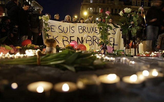 People hold a banner reading 'Je suis Bruxelles' (I am Brussels) in tribute to victims at a makeshift memorial in front of the stock exchange at the Place de la Bourse in Brussels on March 22, 2016.  (AFP  / KENZO TRIBOUILLARD)
