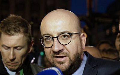 Belgian Prime Minister Charles Michel speaks to the press at a makeshift memorial in front of the stock exchange at the Place de la Bourse (Beursplein) in Brussels on March 22, 2016, following triple bomb attacks in the Belgian capital that killed about 35 people and left more than 200 people wounded. (AFP PHOTO / KENZO TRIBOUILLARD)