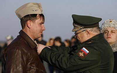 A Russian top officer (R) decorates a Russian air force pilot with a medal upon his arrival from Syria at an airbase in the southern Russia's Krasnodar region, on March 16, 2016. (AFP PHOTO / SERGEI VENYAVSKY)