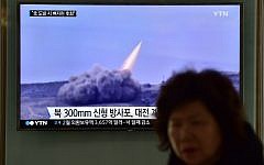 File: A woman walks past a public television screen showing file footage of a North Korean missile, at a railway station in Seoul, March 4, 2016. (AFP/JUNG YEON-JE)