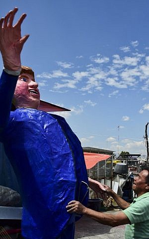 Mexican craftsman Felipe Linares gestures next to his dummy representing US Republican presidential candidate Donald Trump at his workshop in Mexico City on March 24, 2016 (AFP / RONALDO SCHEMIDT)
