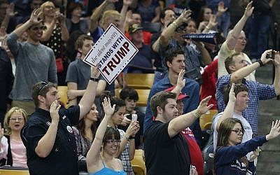 People raise their arms as Republican presidential candidate Donald Trump asks them to pledge that they will vote for him during a campaign rally at the CFE Arena on the campus of the University of Central Florida on March 5, 2016 in Orlando, Florida. ( Joe Raedle/Getty Images/AFP)