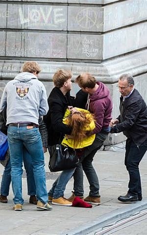 An injured woman is led away as far-right demonstrators protest at a memorial site at the Place de la Bourse in Brussels, Sunday, March 27, 2016. (AP Photo/Geert Vanden Wijngaert) An injured woman is led away as far-right demonstrators protest at a memorial site at the Place de la Bourse in Brussels, Sunday, March 27, 2016. (AP Photo/Geert Vanden Wijngaert)