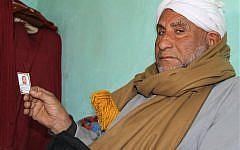 In this Feb. 16, 2016 photo, Qenawi Hamdan, holds a photo of his slain son, Mohammed Hamdan, at the family house in Beni Suleiman village, south of Cairo, Egypt. The 32-year-old Egyptian government engineer disappeared in mid-January when, according to witnesses, masked police burst into his office in the southern city of Beni Suef and dragged him off in handcuffs in front of his co-workers. (AP Photo/Maggie Michael)